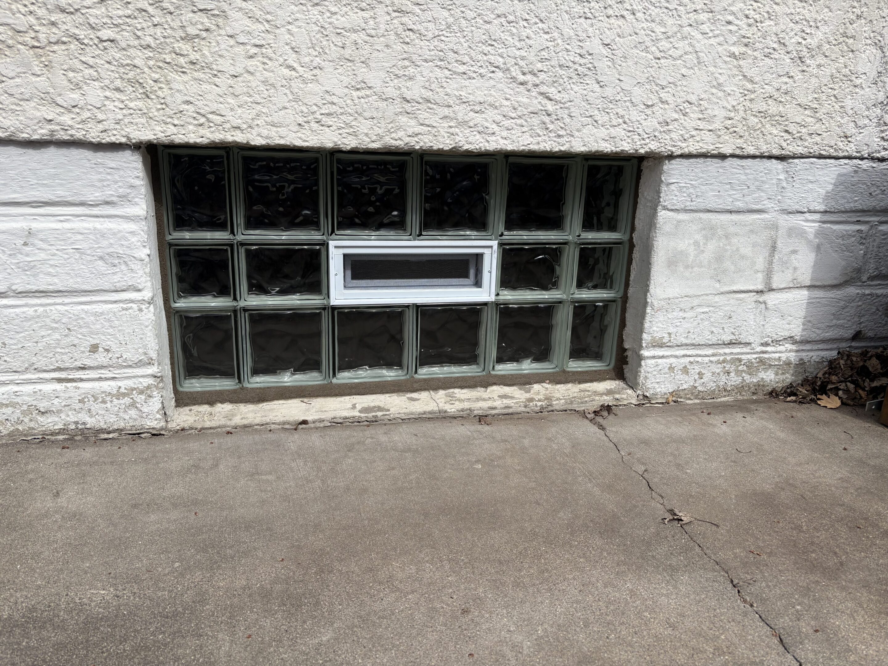 White-trimmed glass block basement window